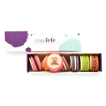 Луксозна кутия с френски макарони от Chez Fefe, в която всеки макарон е декориран с различна плочка с надпис „Happy Birthday“ и празнични илюстрации на торти, свещички и балони.