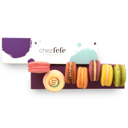 Цветни френски макарони, подредени пред брандирана кутия Chez Fefe, с акцент върху макарон с кръгъл надпис „Честит Имен Ден!“.